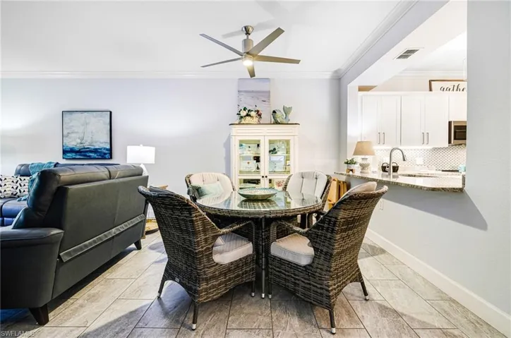 Dining space with ceiling fan, ornamental molding, and sink