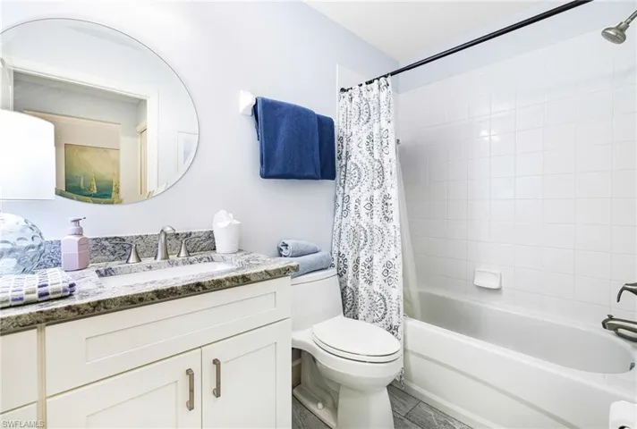 Full bathroom with vanity, shower / tub combo, and toilet