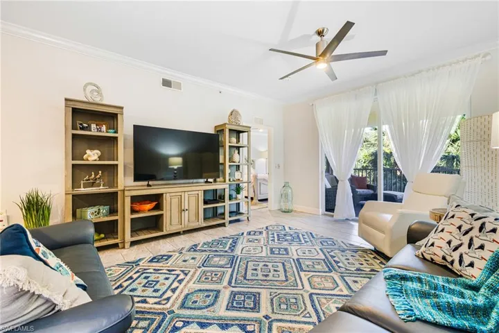 Living room with ceiling fan and crown molding
