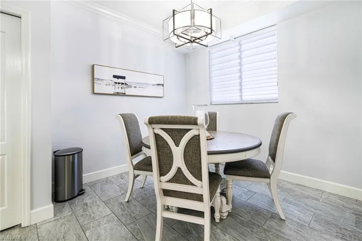 Dining room with a notable chandelier and ornamental molding
