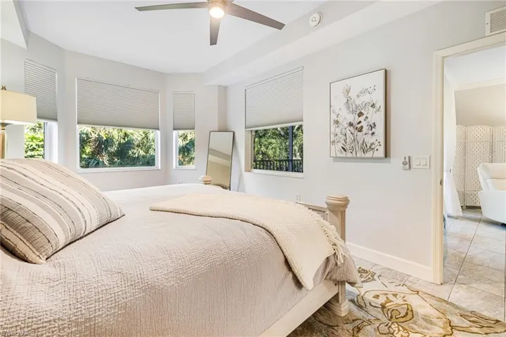 Tiled bedroom featuring ceiling fan