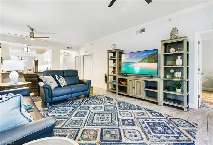 Living room with ceiling fan and ornamental molding