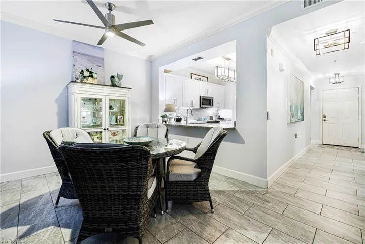 Dining area with ceiling fan and ornamental molding