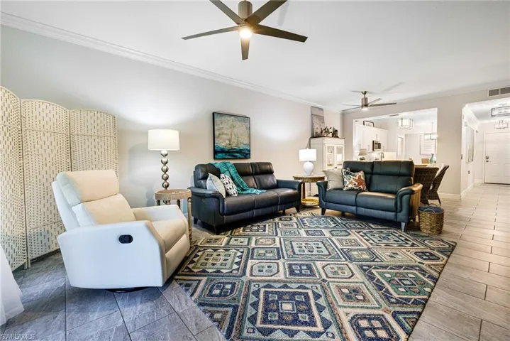 Living room featuring ceiling fan and crown molding