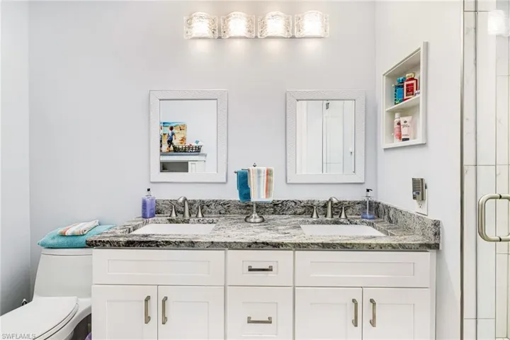 Bathroom featuring vanity, toilet, and a shower with shower door