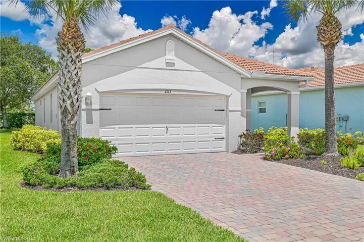 Mediterranean / spanish-style house with stucco siding, driveway, a garage, and a tiled roof