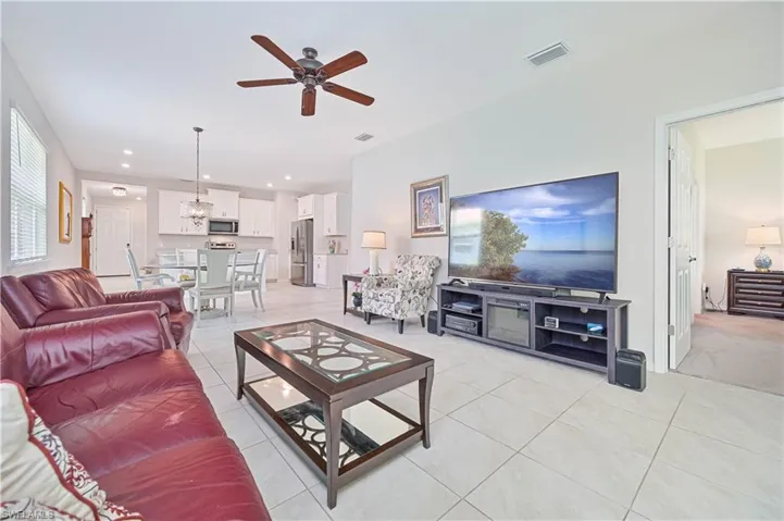 Living room featuring a ceiling fan, light tile patterned floors, a chandelier, and recessed lighting