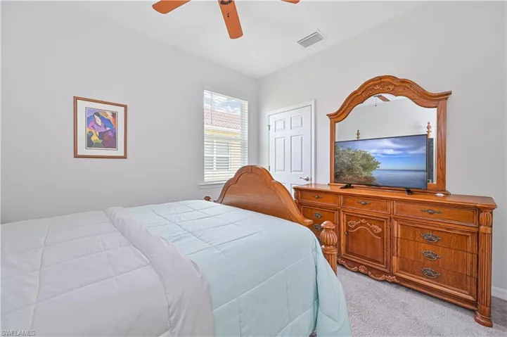 Bedroom featuring light colored carpet and a ceiling fan