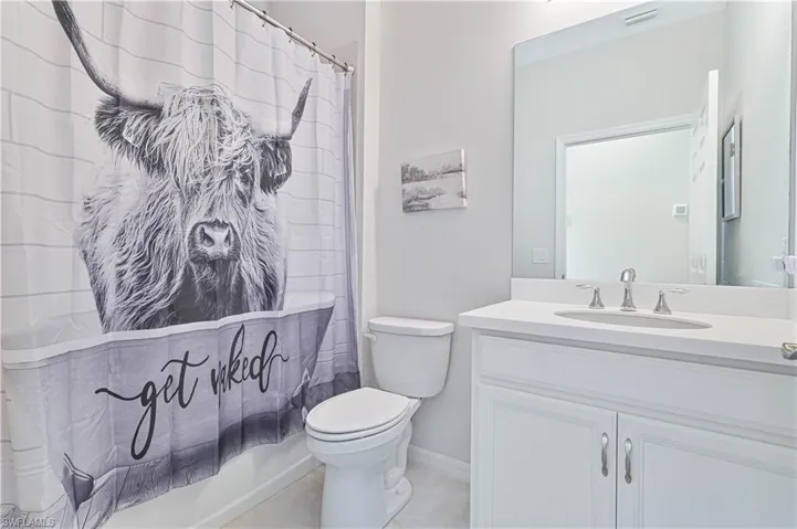 Bathroom featuring vanity, shower / bath combo, and tile patterned floors