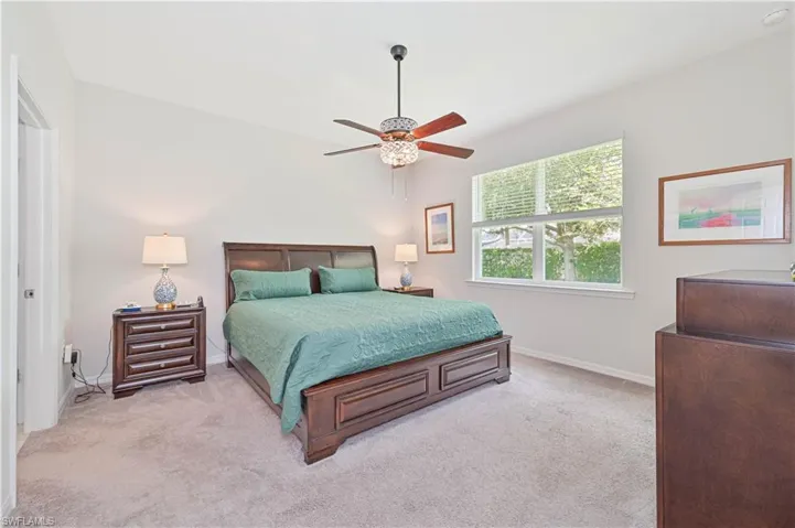 Bedroom with light carpet and a ceiling fan