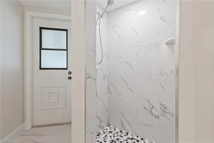Guest & Pool Bath. Newly Tiled Shower Area matches Stone Accent behind Vanity.