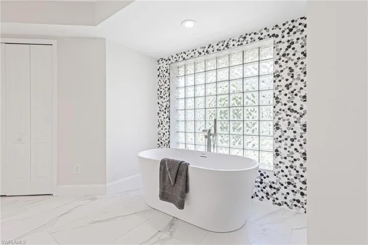 Stone Accent, Freestanding Tub with Stainless Filler and Handheld Sprayer.