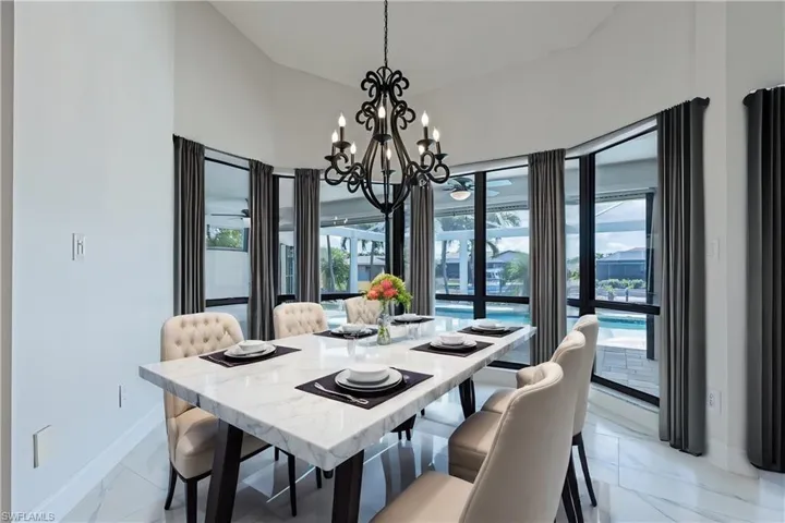 VIRTUALLY STAGED-Dining area with a notable chandelier, a wealth of natural light, and light tile floors