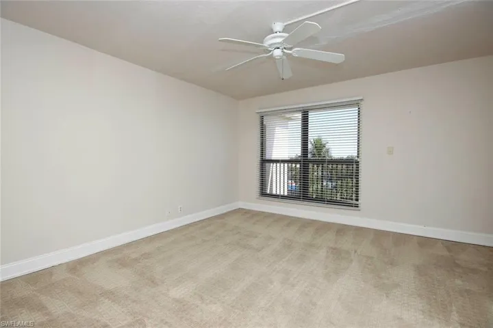 Guest bedroom with light colored carpet, ceiling fan.