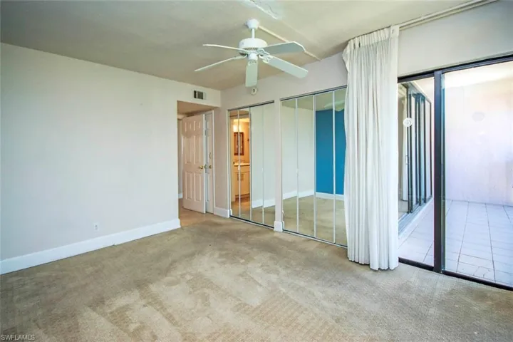 Unfurnished bedroom featuring carpet flooring, baseboards, two closets, and a ceiling fan