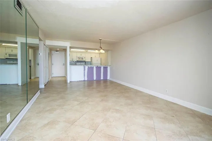 Unfurnished living room featuring baseboards