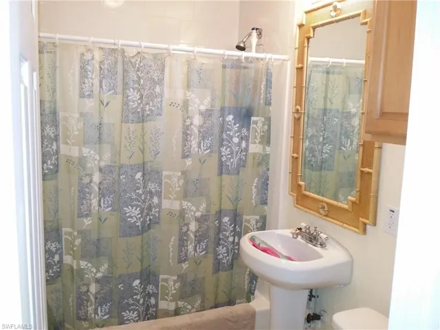 Full bathroom with a shower with curtain and toilet