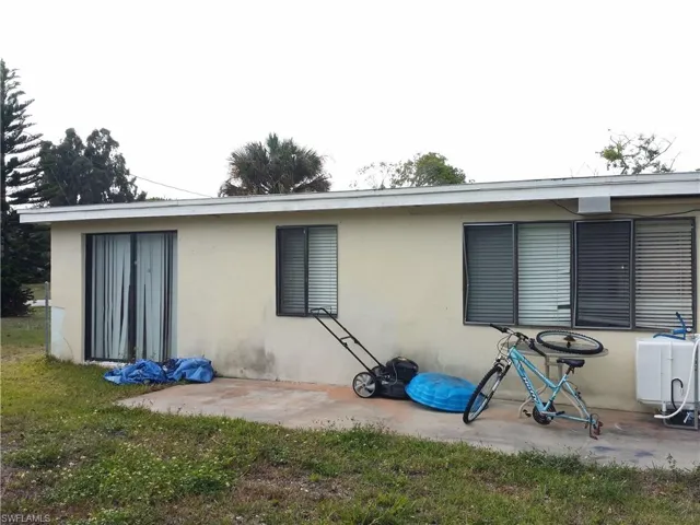 Back of property with stucco siding, a patio, and a lawn