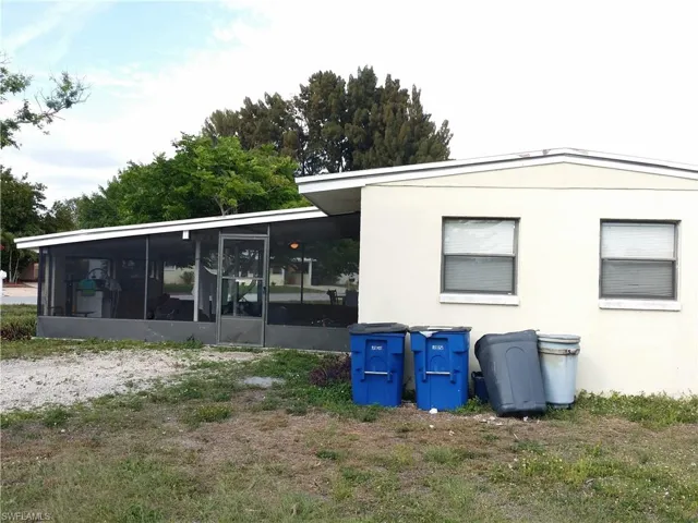 Back of house featuring a sunroom and stucco siding