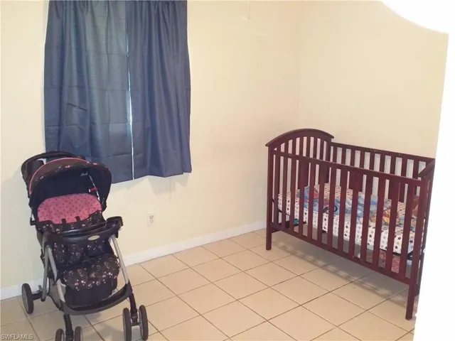 Bedroom with a crib and baseboards