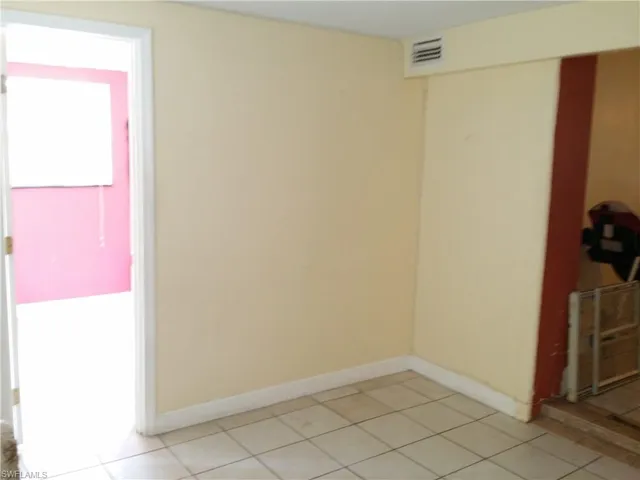 Empty room featuring baseboards and light tile patterned flooring