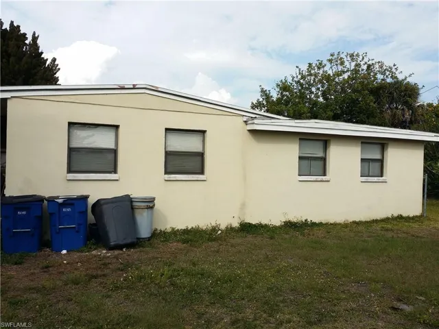 View of side of property featuring a yard and stucco siding