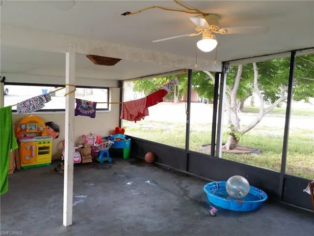 Unfurnished sunroom featuring ceiling fan