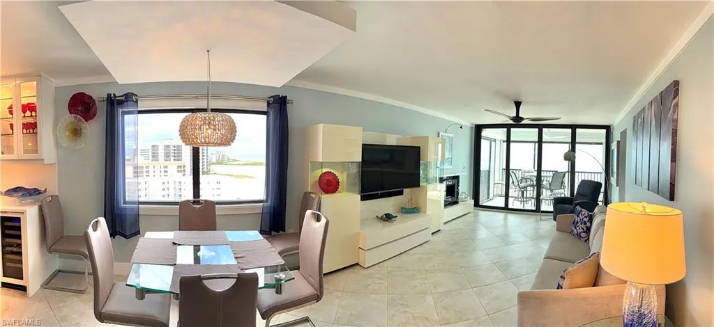 Open-concept living area featuring polished concrete flooring, recessed ceiling lighting, and expansive windows with black-framed glass doors providing natural illumination
