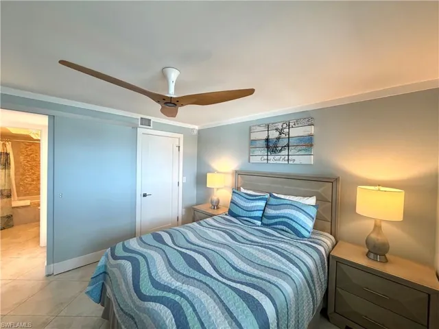 Spacious room featuring a wood-blade ceiling fan, light-colored tile flooring, and a sliding pocket door