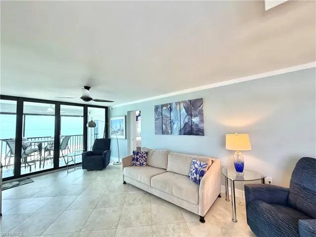 tile flooring,  upgraded ceiling fan, crown molding, and expansive glass sliding doors accessing the outdoor balcony