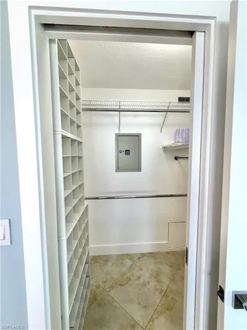 Walk-in closet with built-in shelving, wire racks, and tile flooring and wall safe