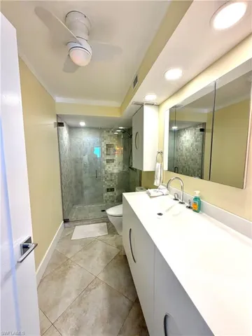 Modern primary bathroom featuring a floating vanity with rectangular vessel sink, quartz countertop, and chrome faucet