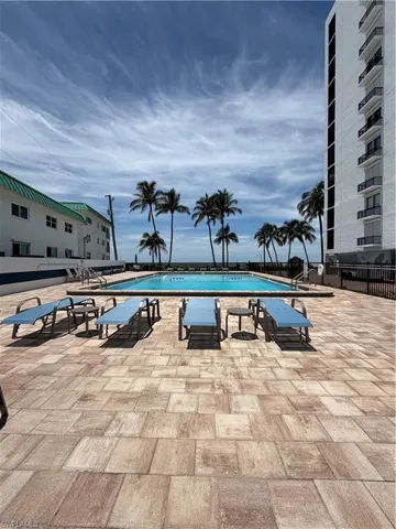 a Gulfside swimming pool surrounded by a paver deck and lounge chairs.