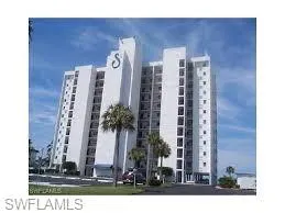 Multi-story residential building with private balconies and a prominent exterior letter "S" design element