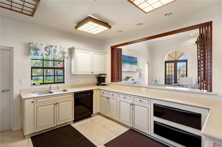 Kitchen with a healthy amount of sunlight, light countertops, dishwasher, and a sink