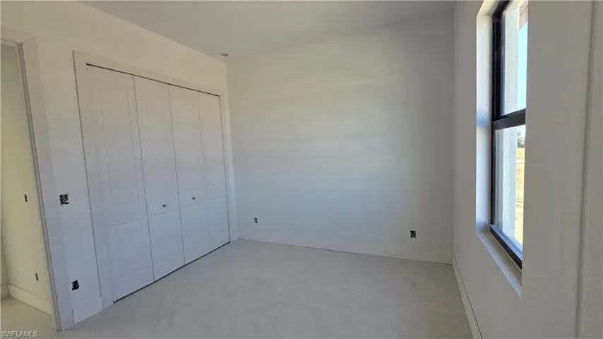 Unfurnished bedroom featuring a closet and concrete flooring
