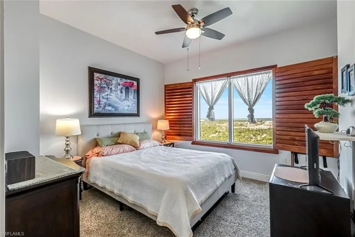 Carpeted bedroom featuring baseboards and ceiling fan