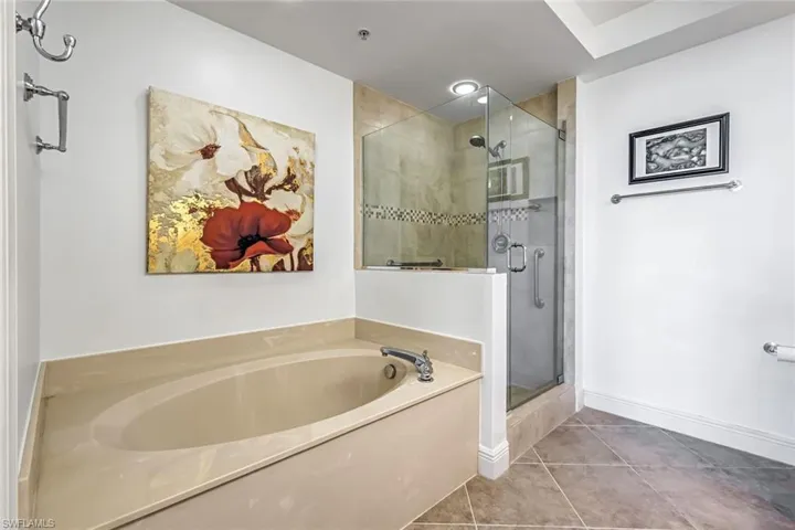 Full bath featuring a stall shower, tile patterned floors, and a garden tub