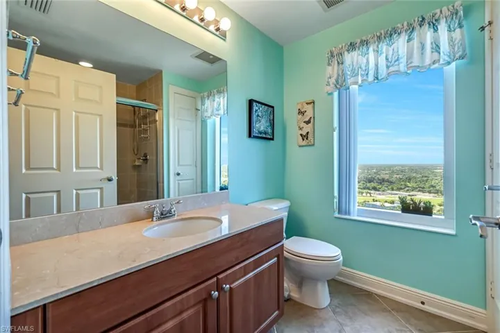 Full bath with vanity, light tile patterned flooring, and a stall shower