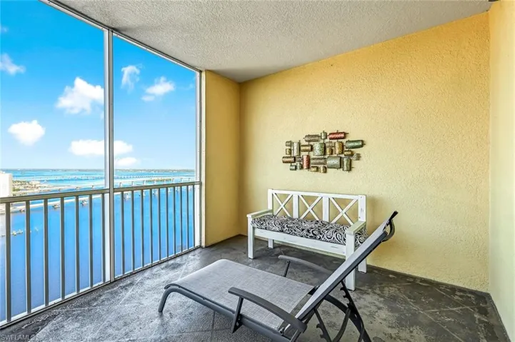 Balcony featuring a water view and a sunroom