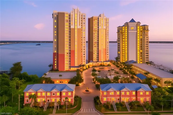 Aerial view at dusk of a water view and a view of apartment building / complex