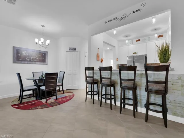 Tiled dining space featuring a notable chandelier