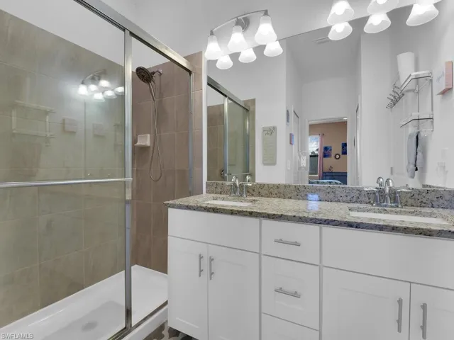 Bathroom featuring vanity and a shower with door