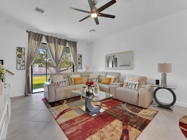 Living room with tile patterned flooring and ceiling fan
