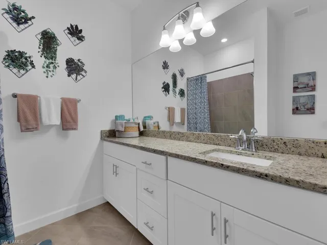 Bathroom with tile patterned flooring, vanity, and curtained shower
