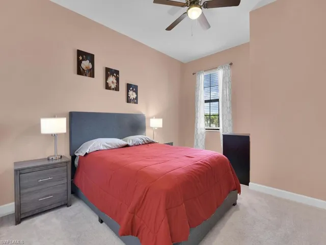Carpeted bedroom featuring ceiling fan
