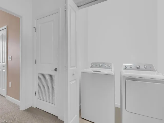 Washroom featuring light colored carpet and separate washer and dryer