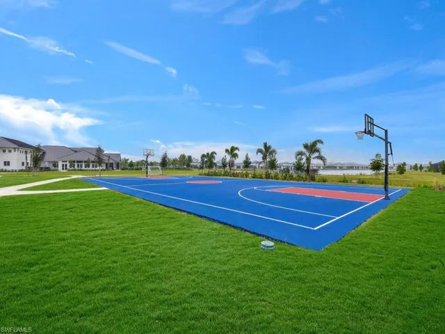 View of sport court with a yard
