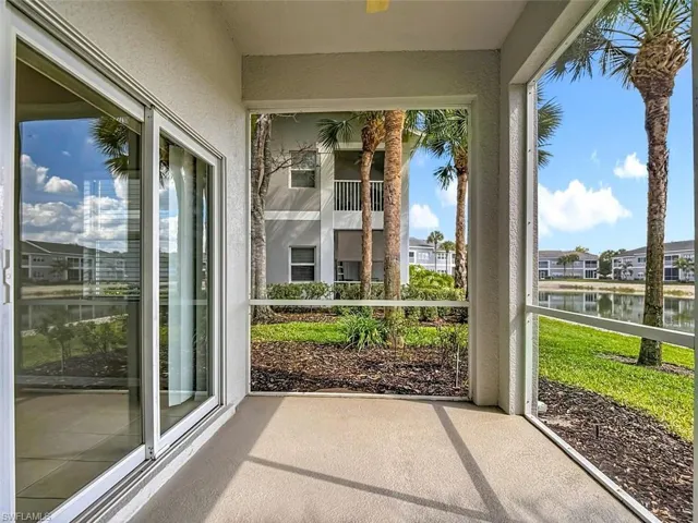 Unfurnished sunroom featuring a water view and a residential view