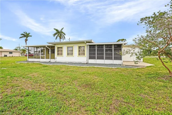 Back of house featuring a sunroom and a yard